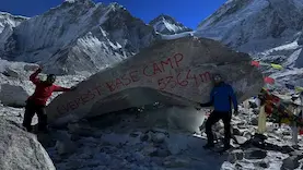 Elysian Quest Team taking picture infront of iconic everest base camp stone